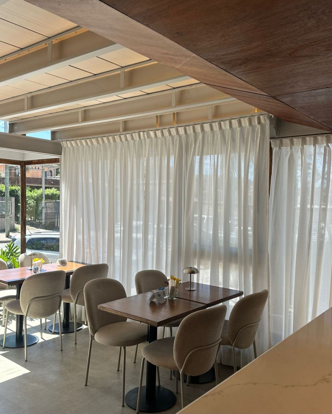 Mesas y sillas entre las cortinas del salón
